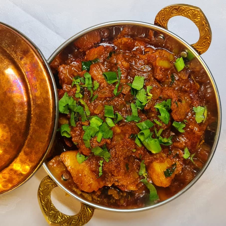 Lamb balti in a copper dish with fresh coriander